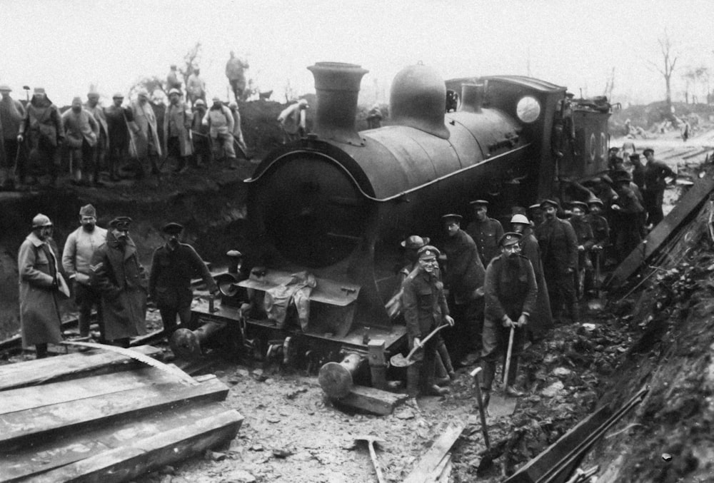 a group of men standing next to a train