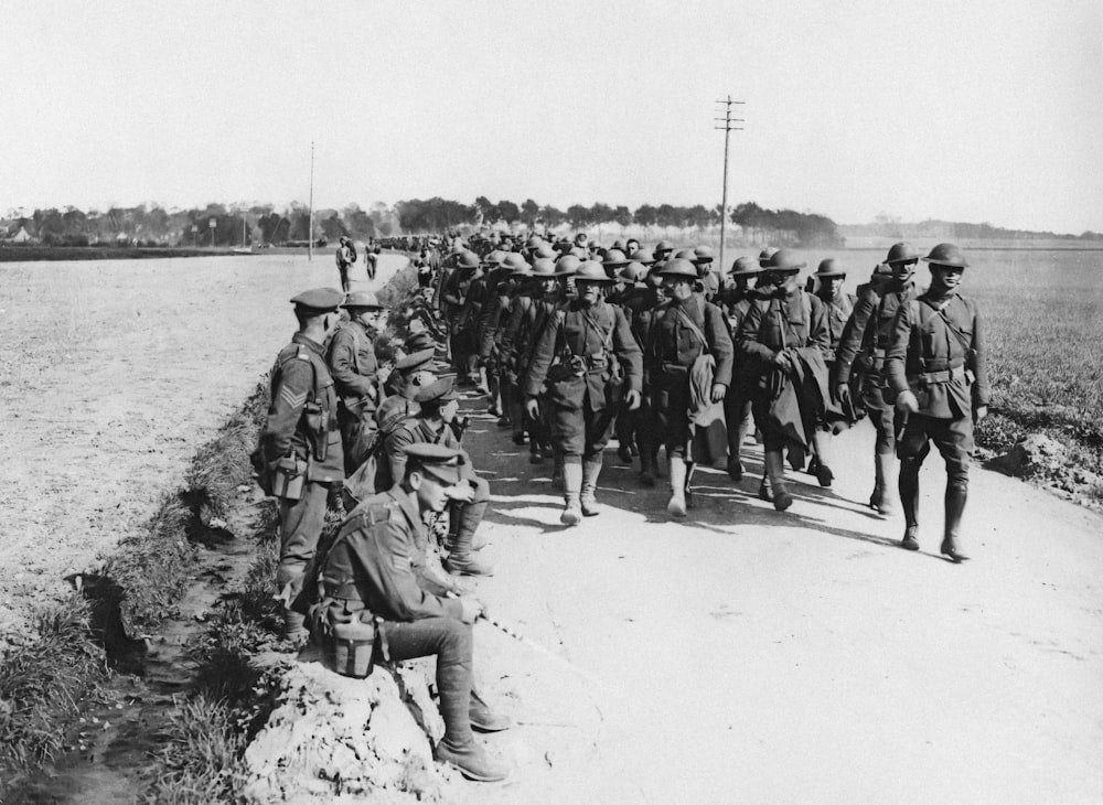 um grupo de soldados caminhando por uma estrada de terra