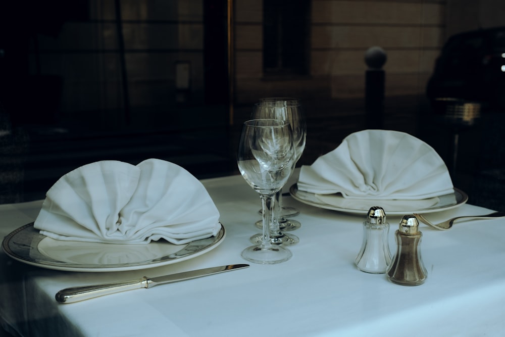 a table with a white table cloth and silverware