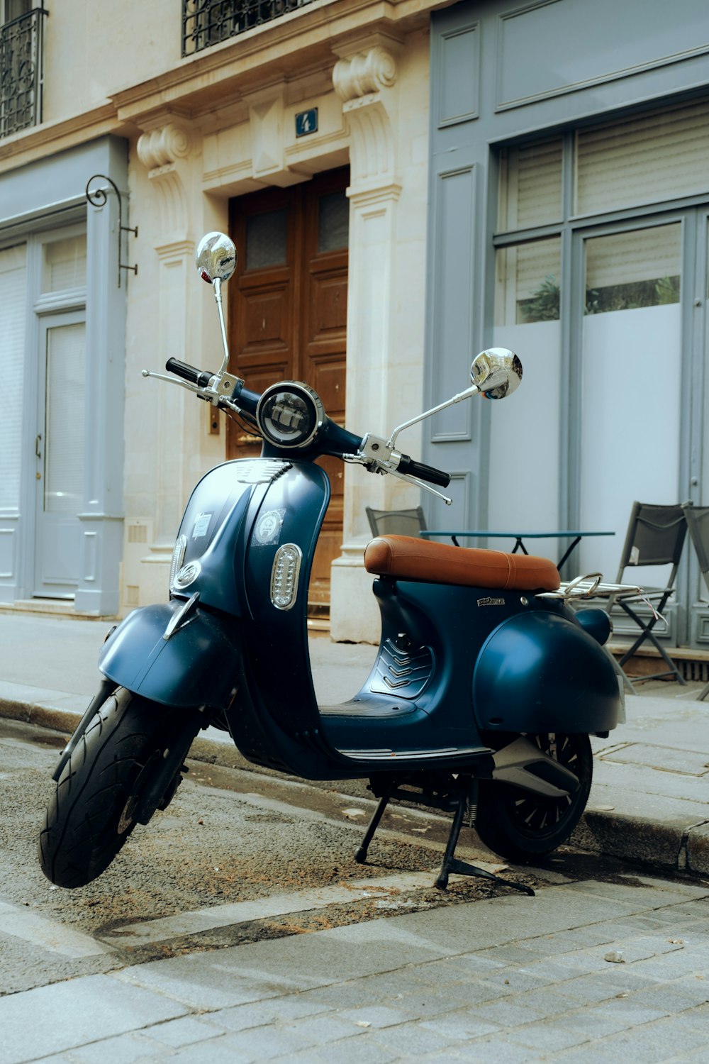 a blue scooter parked on the side of the street