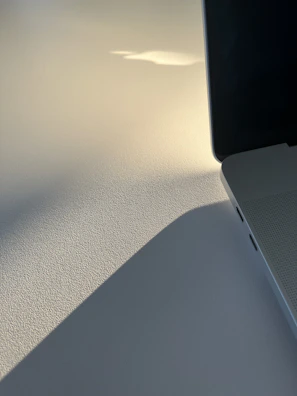 Detail shot of a luxury laptop’s finely crafted hinge and logo emblem.