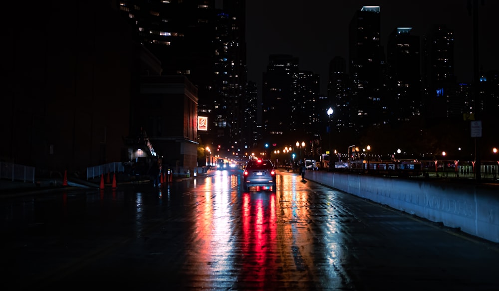 a car driving down a city street at night