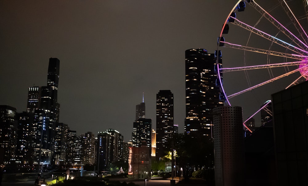 a ferris wheel in the middle of a city at night