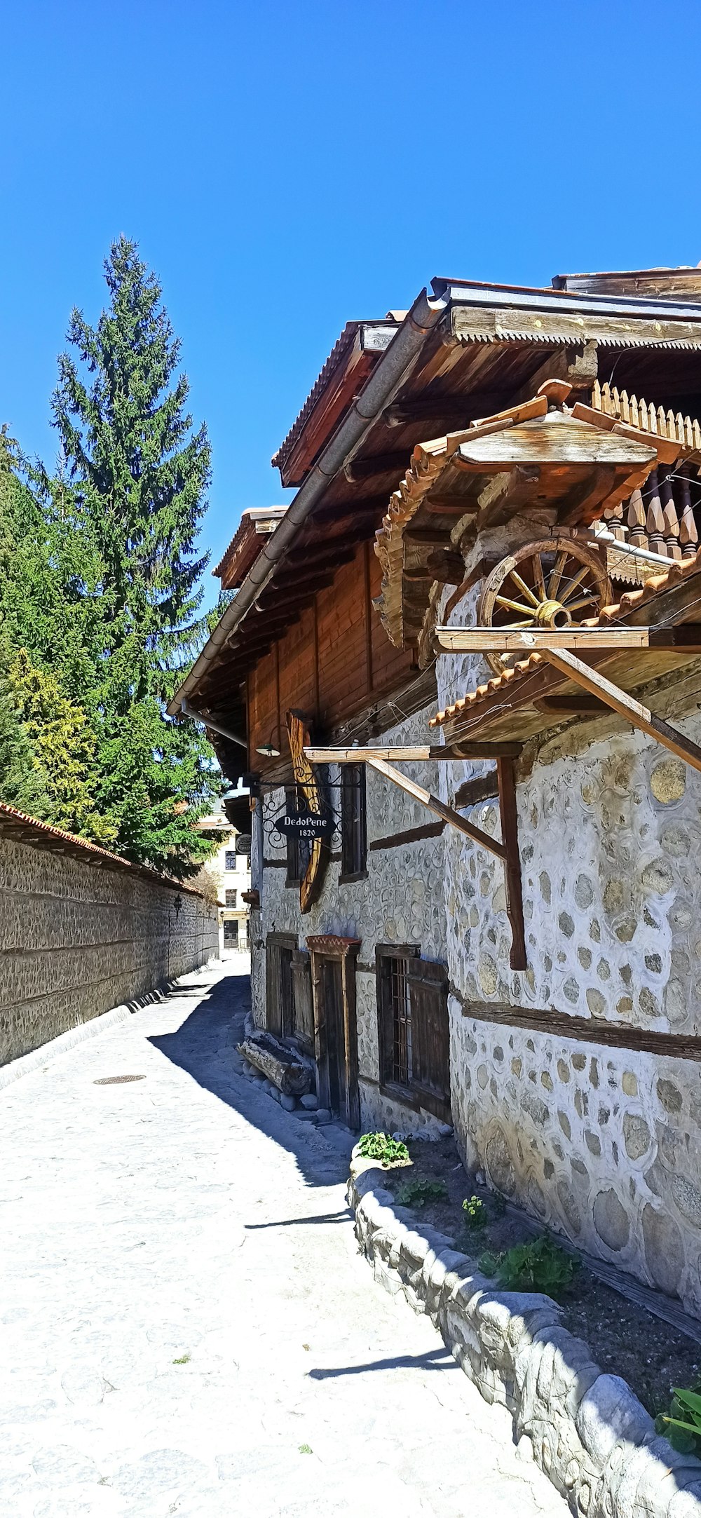 a stone building with a water wheel on the side of it