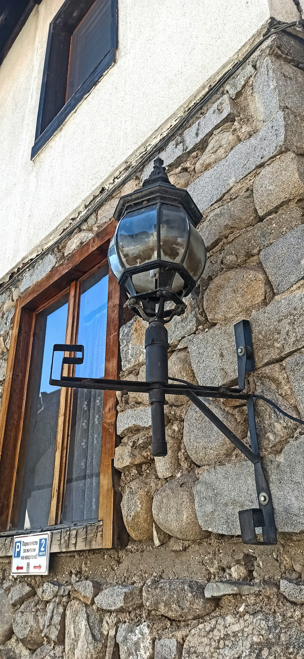 a light on the side of a stone building