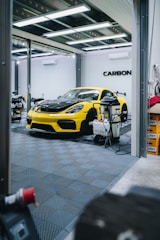 a yellow sports car is parked in a garage