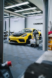 a yellow sports car is parked in a garage