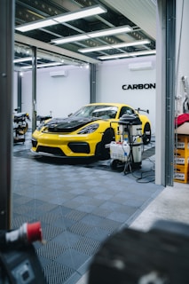 a yellow sports car is parked in a garage
