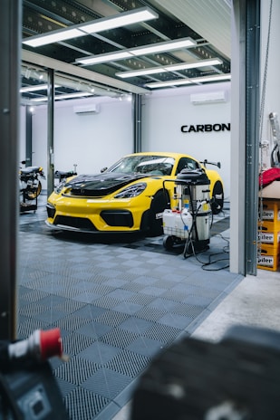 a yellow sports car is parked in a garage