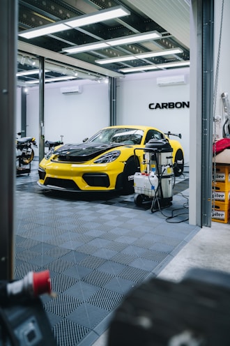 a yellow sports car is parked in a garage