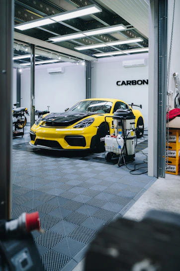 a yellow sports car is parked in a garage
