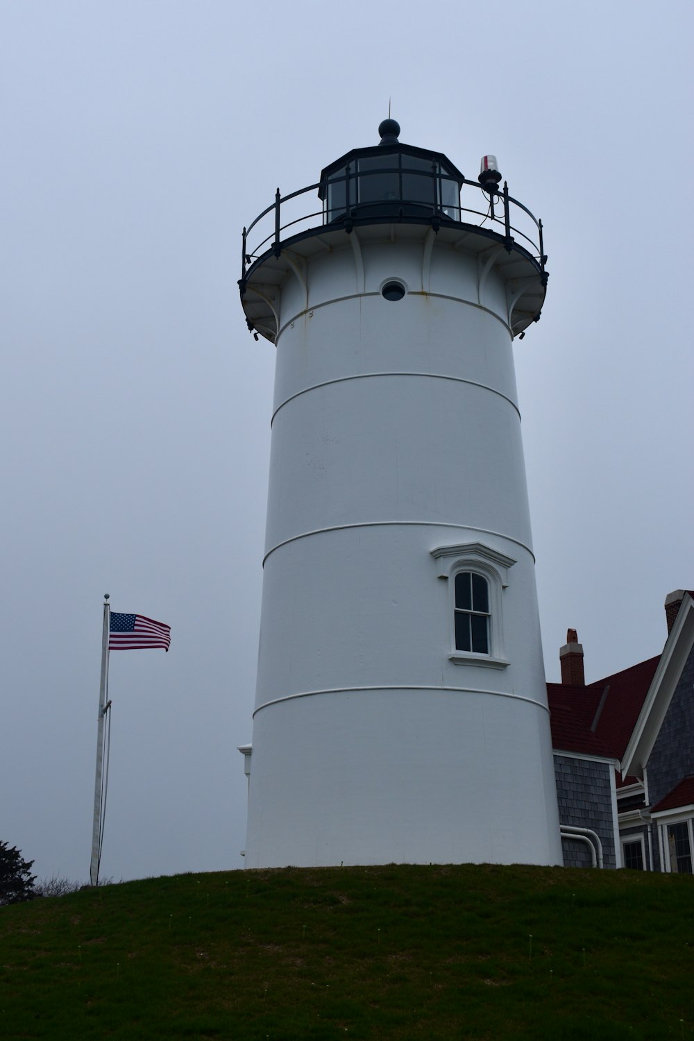 a white lighthouse with a flag on top of it