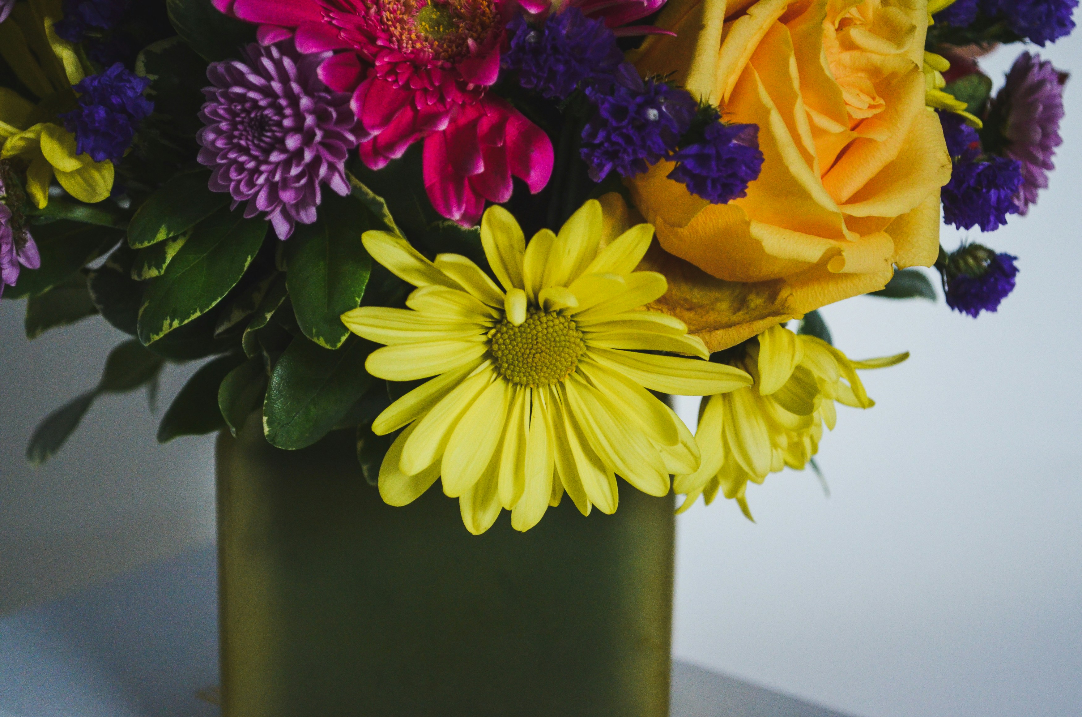 a vase filled with lots of different colored flowers