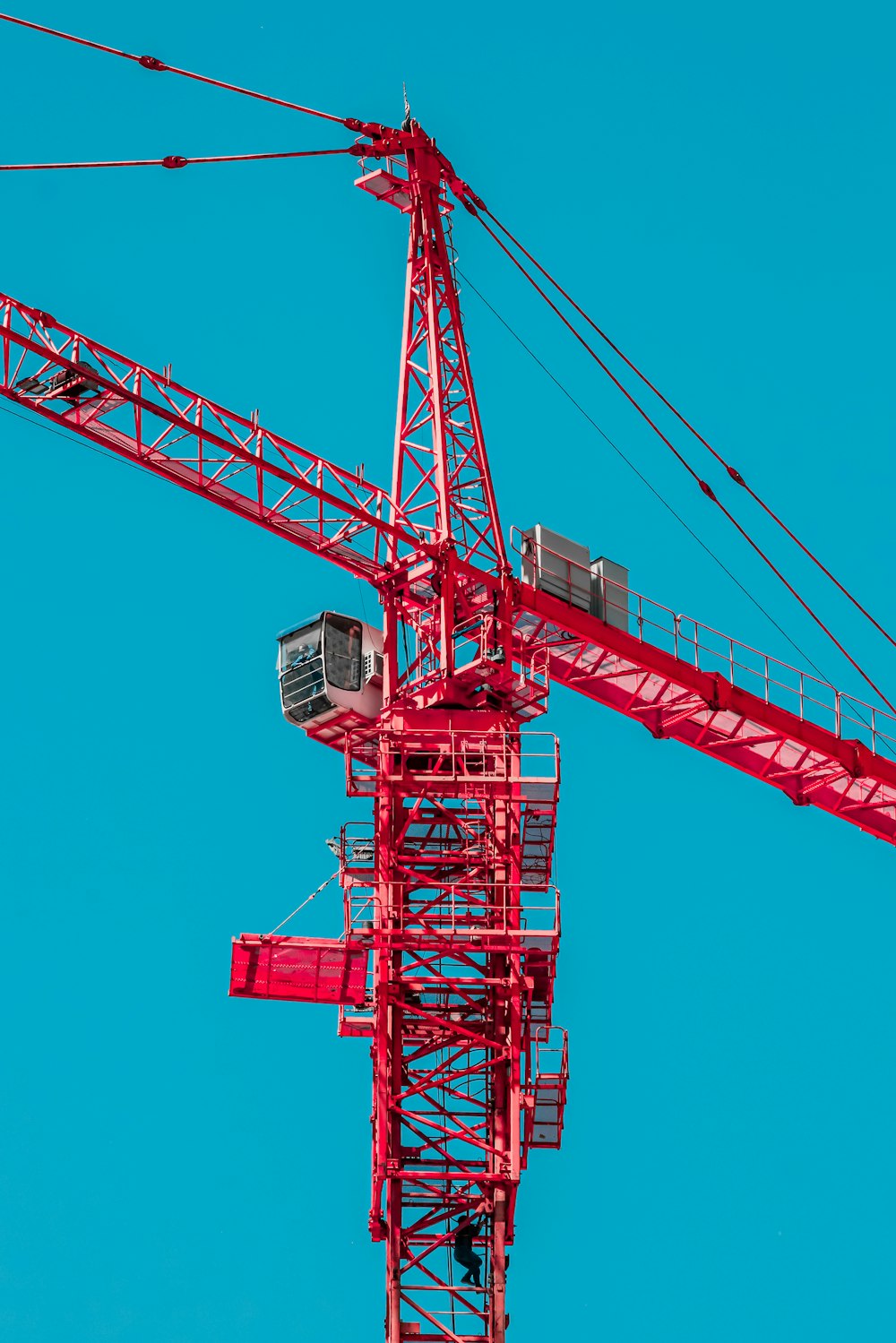 a large red crane is against a blue sky