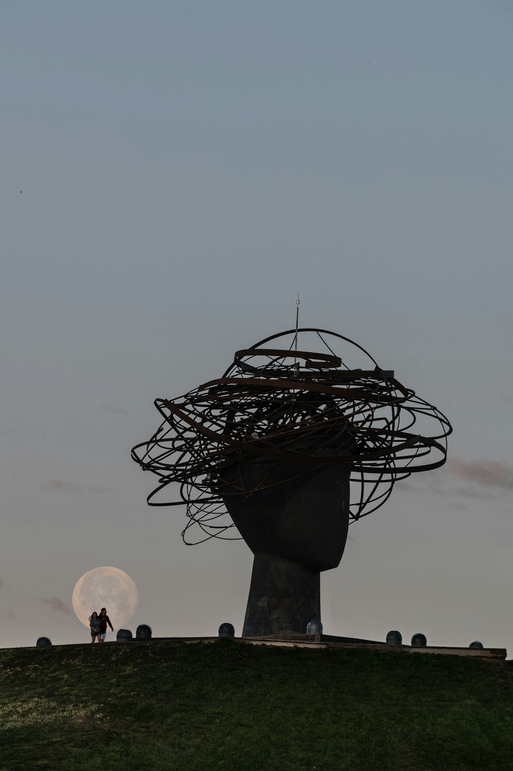 Dos personas de pie en la cima de una colina bajo la luna llena