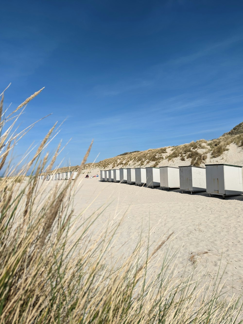 a row of beach huts sitting on top of a sandy beach