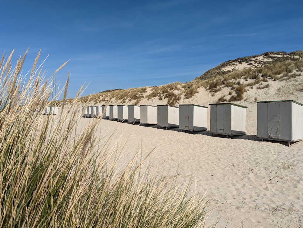 a row of beach huts sitting on top of a sandy beach