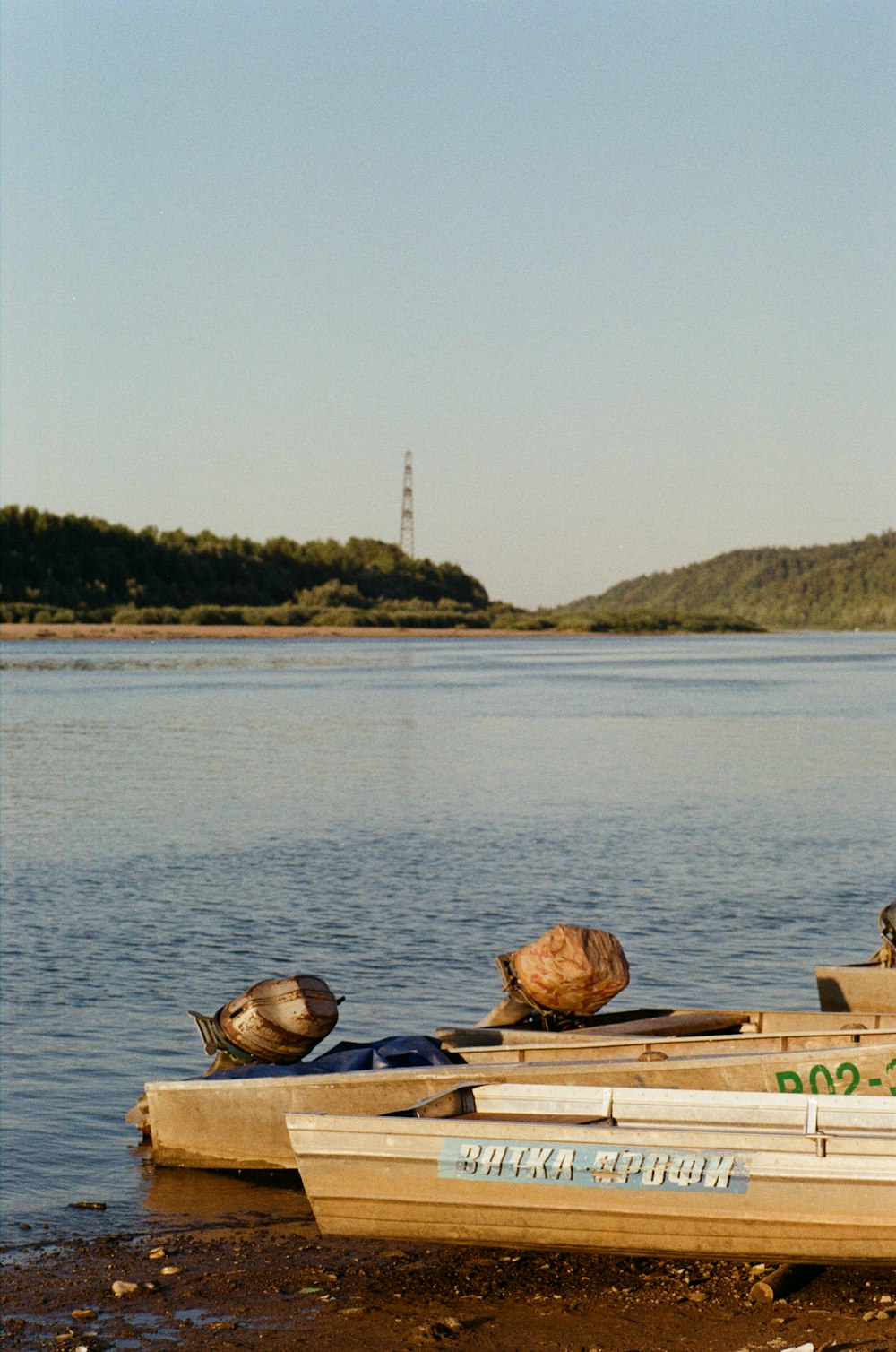 a small boat sitting on the shore of a lake