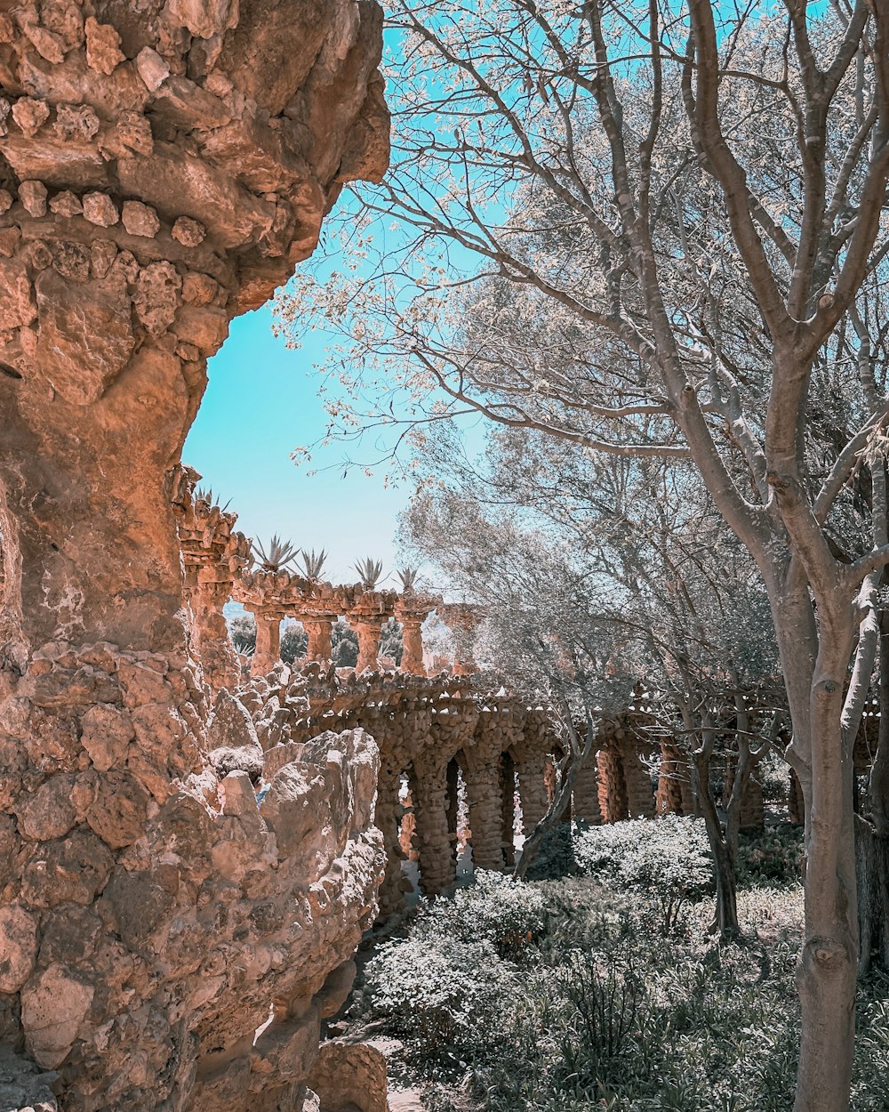 a stone bridge over a river surrounded by trees