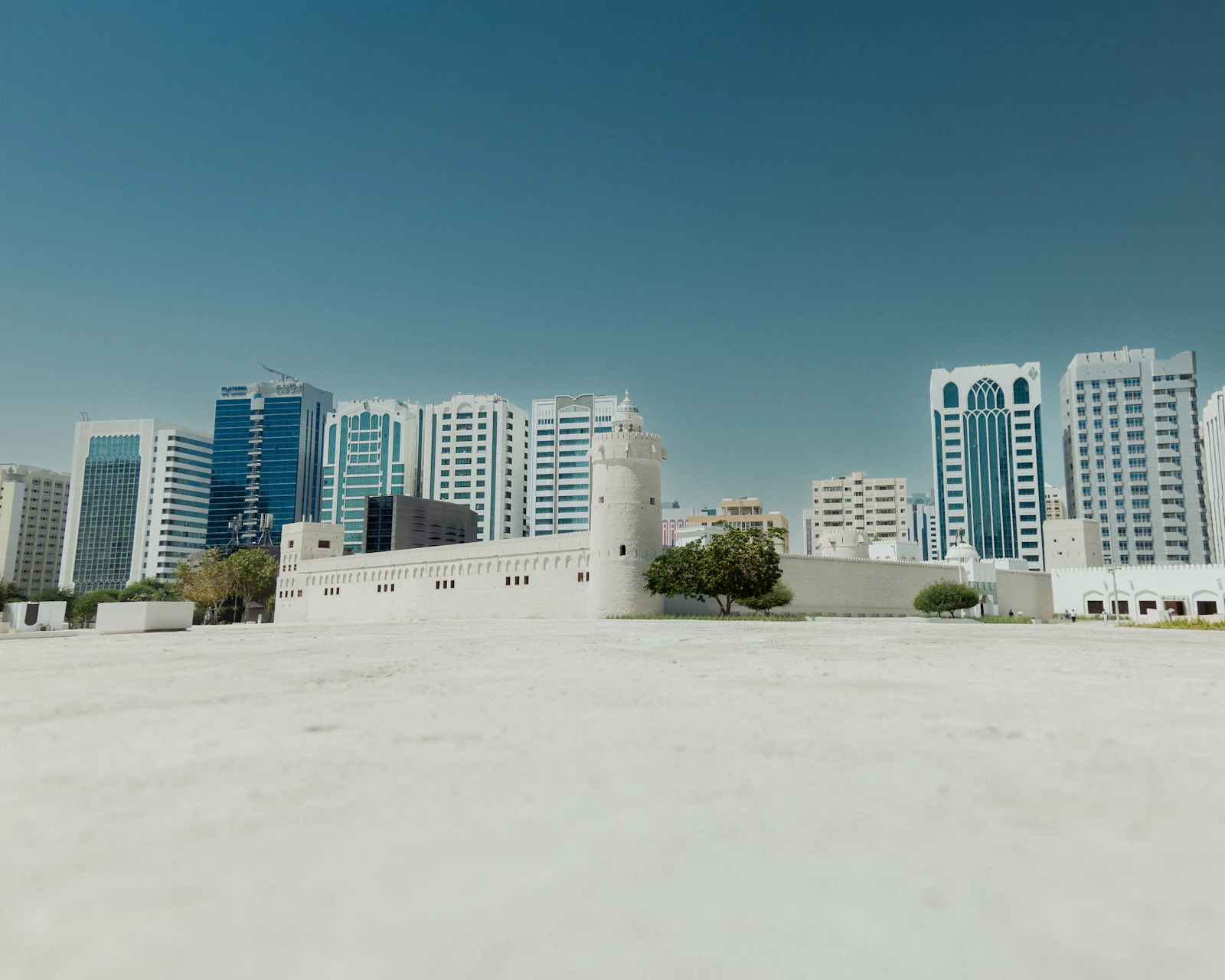 Qasr Al Hosn's white fort walls and towers against central Abu Dhabi's high-rises