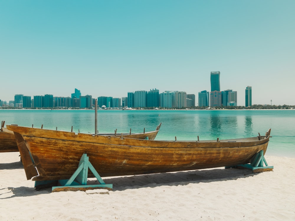 a wooden boat sitting on top of a sandy beach