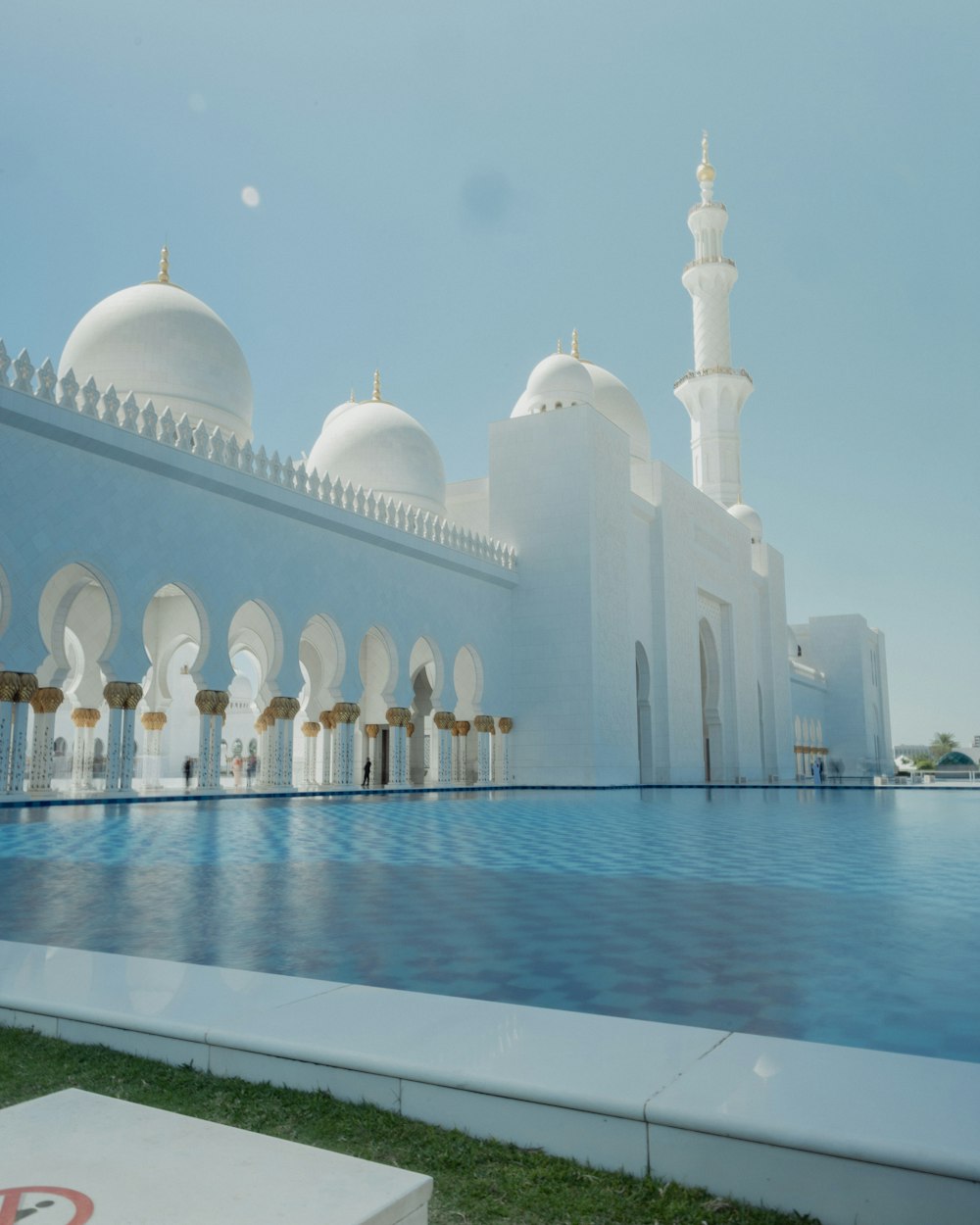 a large white building with a pool in front of it