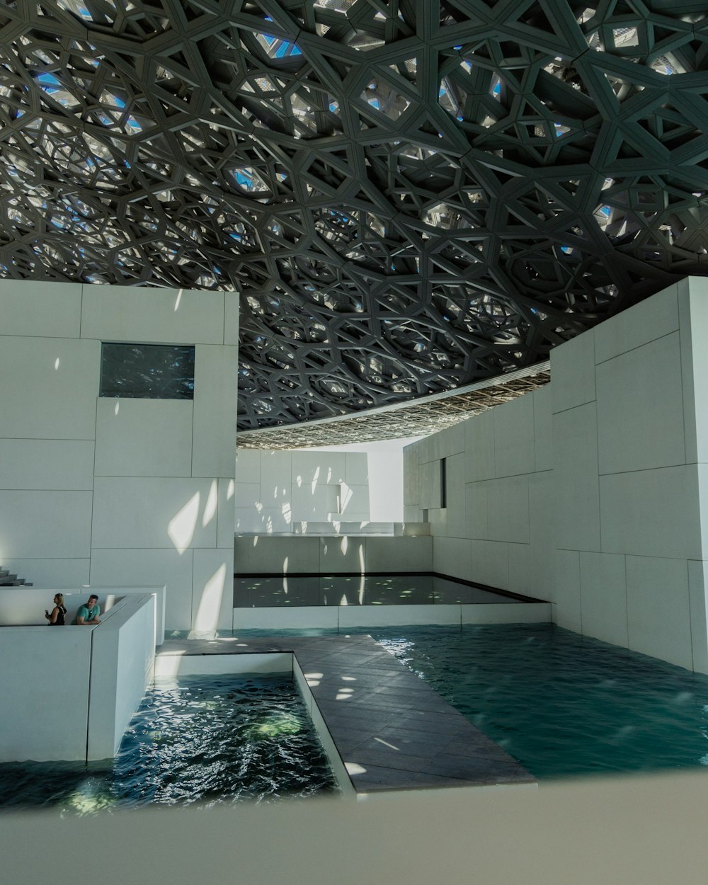 a pool inside of a building with a metal roof