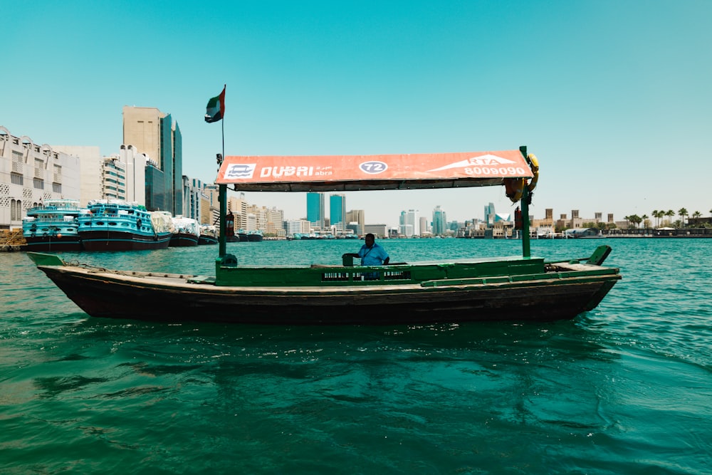 a man is sitting on a small boat in the water