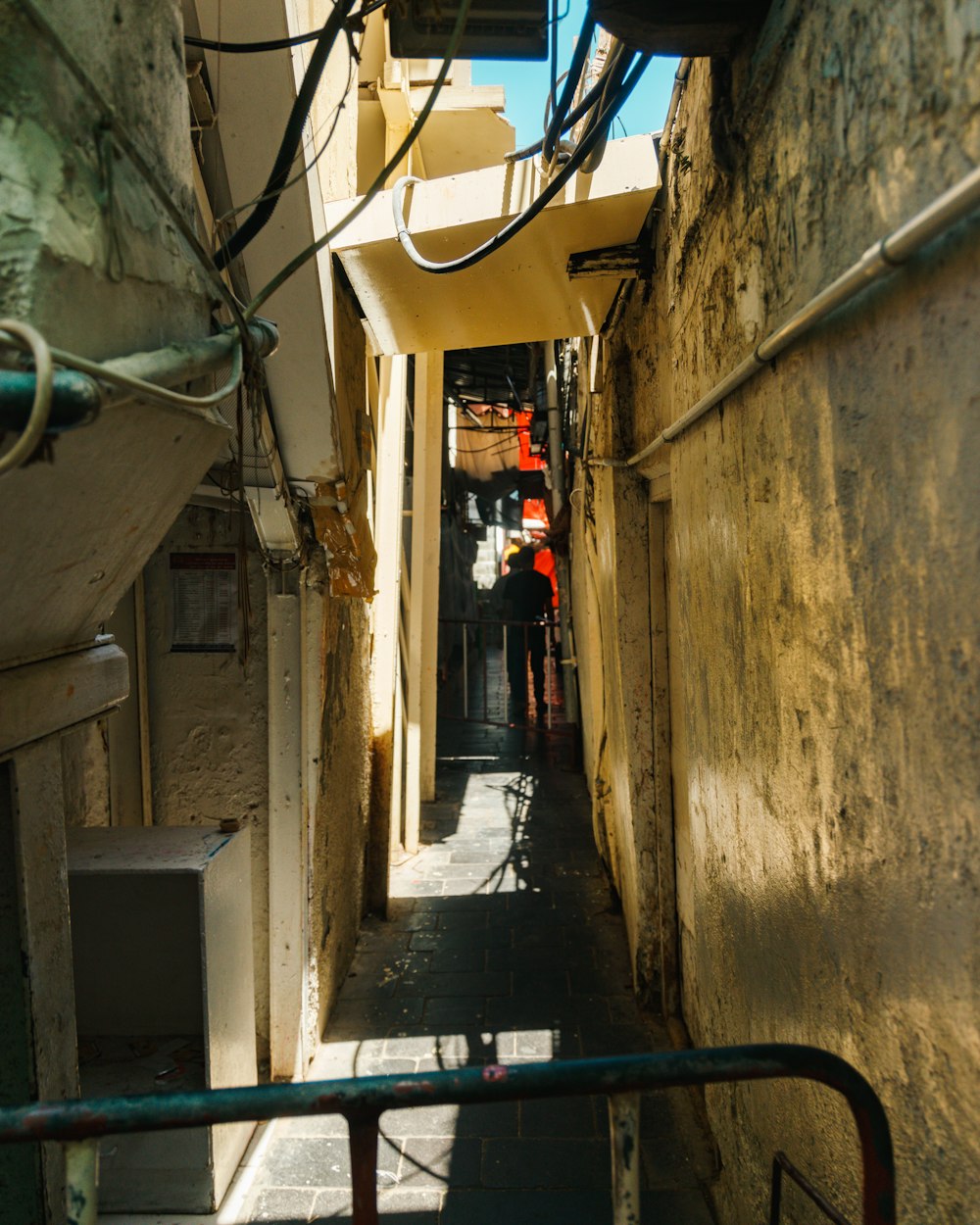 a narrow alley way with people walking down it