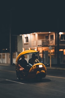 A friendly driver greeting a passenger by a clean, black mini limo under soft evening light.