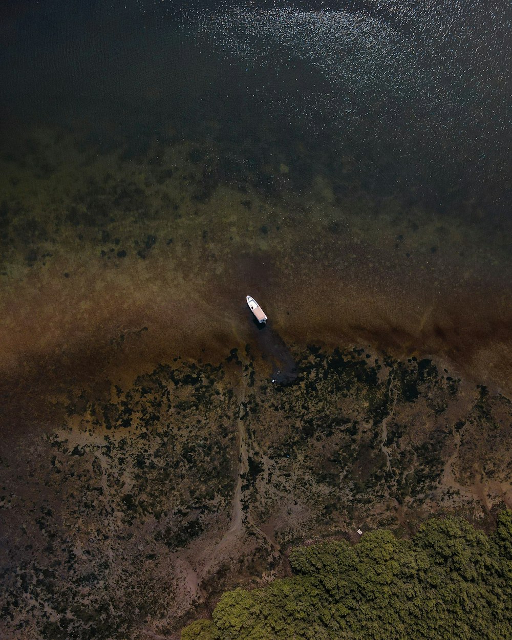 an aerial view of a boat in a body of water