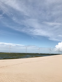 A serene landscape featuring wind turbines and solar panels under a clear blue sky.