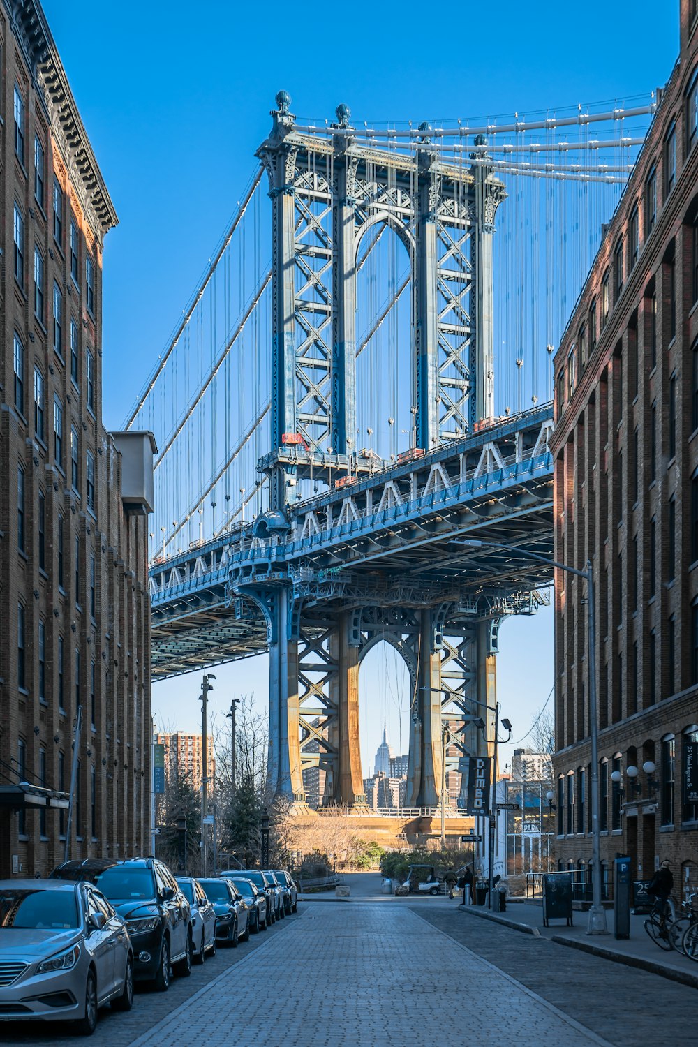 cars parked on the side of the road in front of a bridge