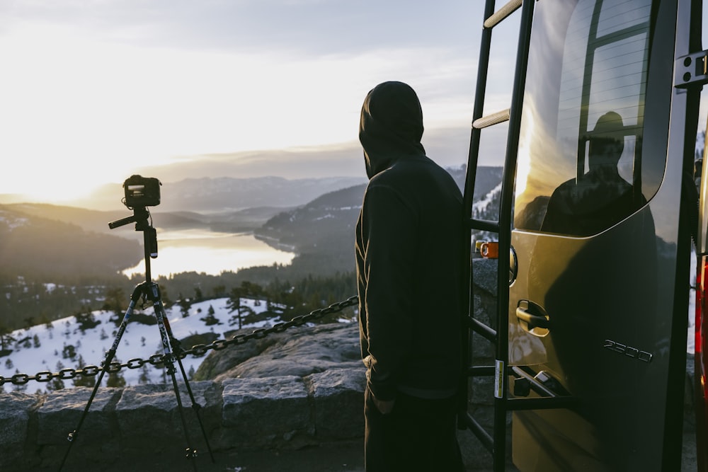 a man standing in front of a camera next to a van