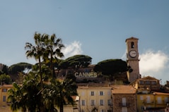 a clock tower on top of a building next to palm trees
