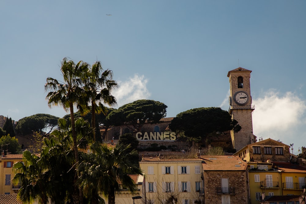 a clock tower on top of a building next to palm trees