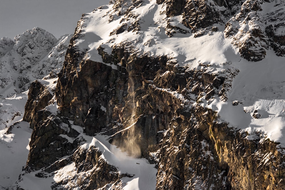 a mountain covered in snow and surrounded by mountains