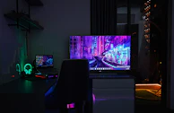 Curved ultra-wide monitor displaying vibrant graphics in a dark tech-themed room