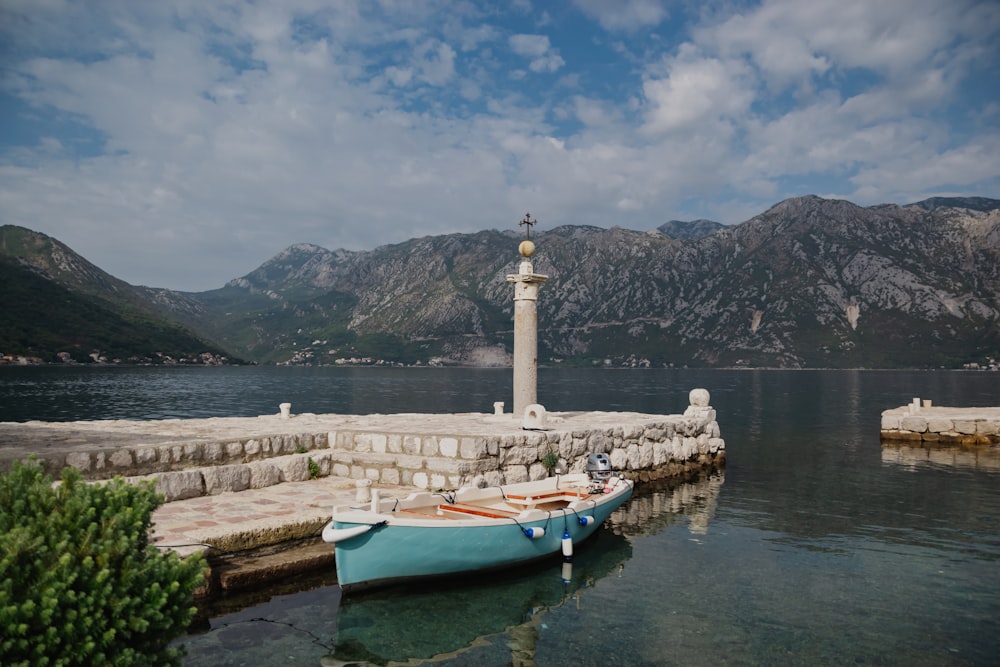 a small blue boat sitting on top of a body of water