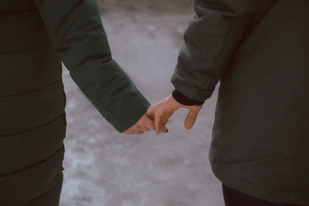a man and woman holding hands while standing next to each other