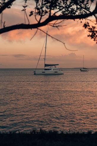 two boats are out on the water at sunset