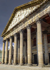 a large building with columns and statues on it