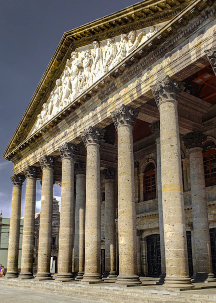 a large building with columns and statues on it