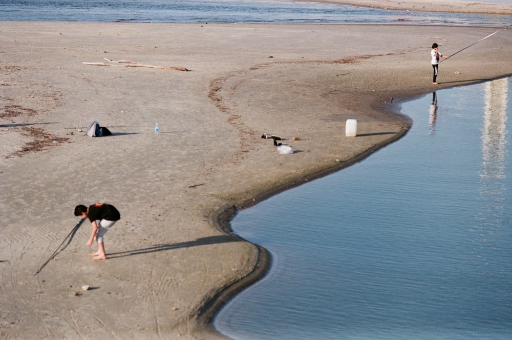 una persona in piedi su una spiaggia vicino a uno specchio d'acqua