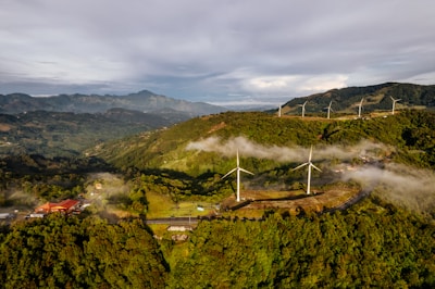 Wind turbines being assembled with green hills in the background.