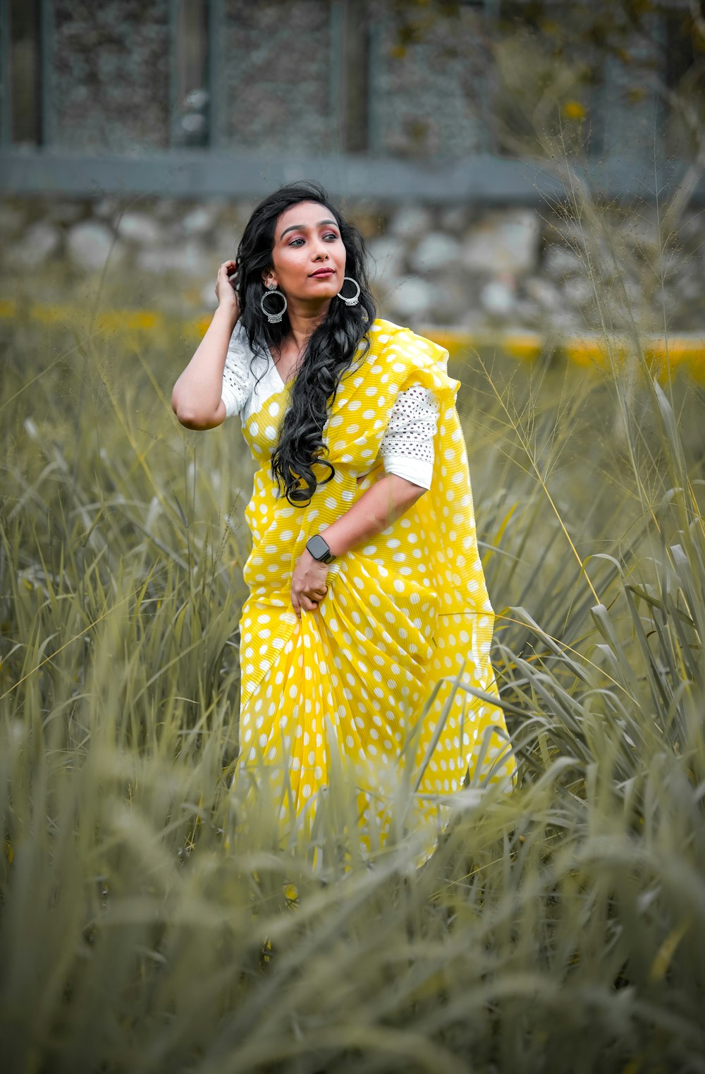 a woman in a yellow dress standing in tall grass