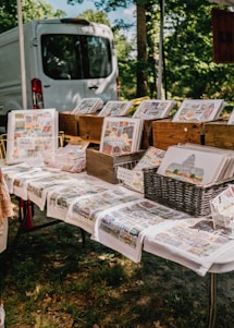 A colorful display of Artsy Grove Gifts' vibrant products including mugs, notebooks, and tote bags arranged on a wooden table.