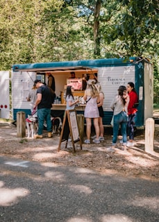 a group of people standing around a food truck