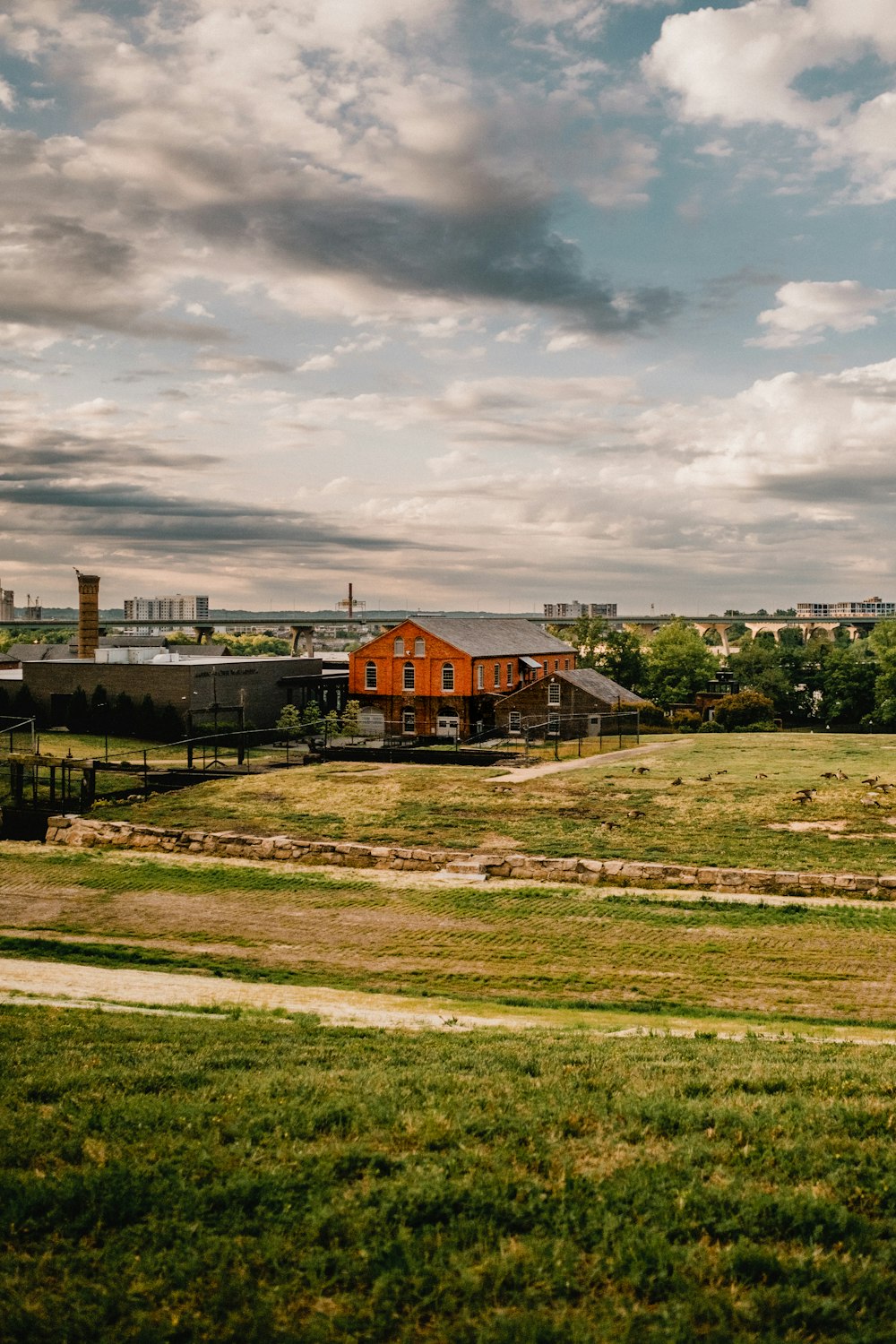 a field with a red building in the distance