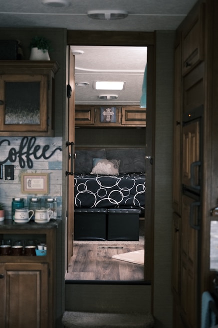 Interior view of a cozy, custom-built camper with warm wood finishes and insulated windows